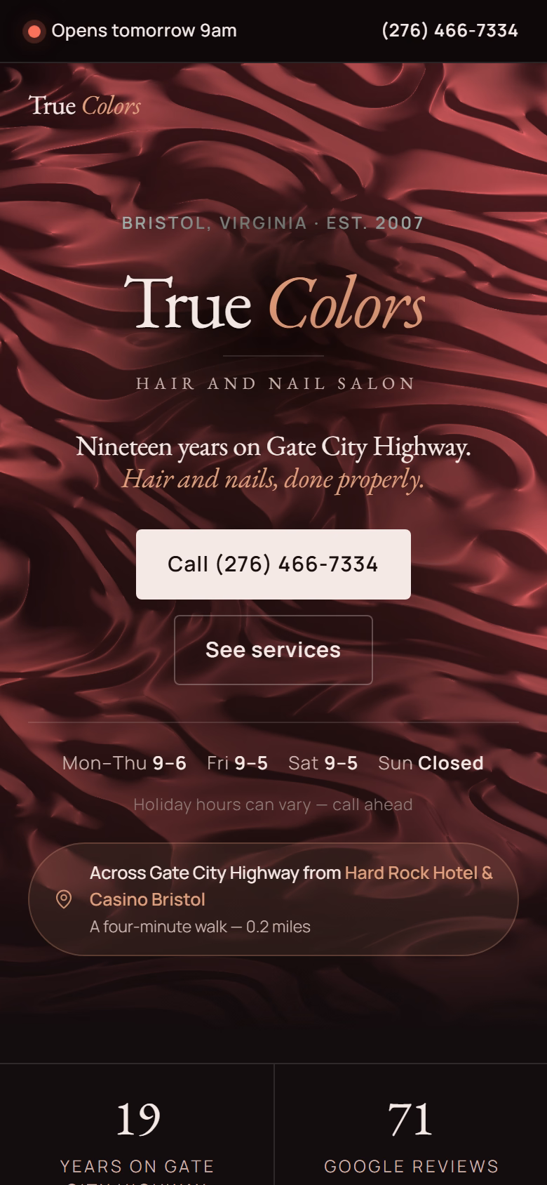 The True Colors salon home page on a phone: the wordmark over a deep red WebGL satin hero, the salon’s hours and phone number, and a stat band reading nineteen years, seventy-one Google reviews and a 4.5 average.